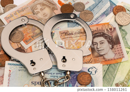 Metal handcuffs on British currency show investigation and arrest in England Metal handcuffs on British currency show investigation and arrest in England 138011261