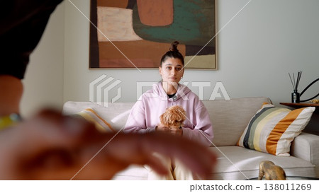 Cozy scene with woman and dog. Woman on sofa with puppy in cozy room Cozy scene with woman and dog. Woman on sofa with puppy in cozy room 138011269