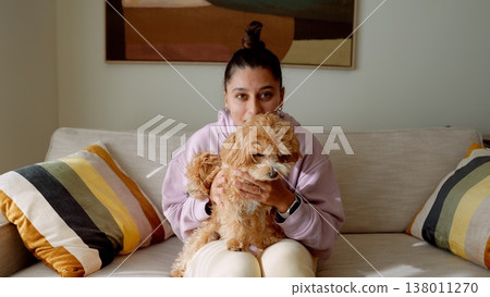 Intimate scene of woman tenderly holding plush dog in warm lighting Intimate scene of woman tenderly holding plush dog in warm lighting 138011270