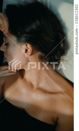 Woman relaxes peacefully post therapy with soft lighting and shadows Woman relaxes peacefully post therapy with soft lighting and shadows 138011302