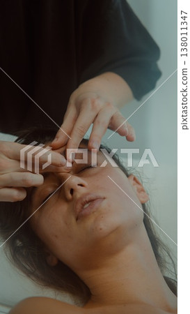 Focus on precise fingertip technique during soothing facial treatment Focus on precise fingertip technique during soothing facial treatment 138011347