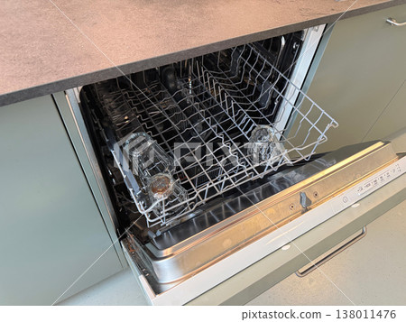Open dishwasher with clean glasses inside modern kitchen appliance Open dishwasher with clean glasses inside modern kitchen appliance 138011476