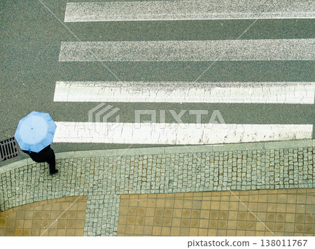Person holding umbrella on street. 138011767