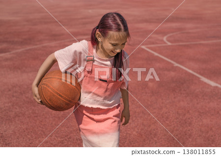 Portrait of a happy girl with a basketball in her hands. Playing basketball and living a healthy lifestyle in step with sports 138011855