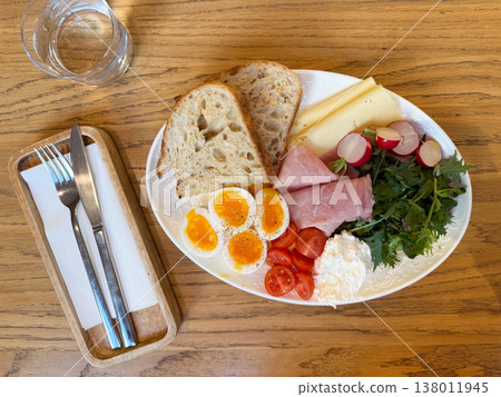 Top view breakfast plate with eggs bread cheese ham and fresh vegetables on wooden table. Balanced nutrition, cafe serving, clean composition, healthy lifestyle Top view breakfast plate with eggs bread cheese ham and fresh vegetables on wooden table. Balanced nutrition, cafe serving, clean composition, healthy lifestyle 138011945