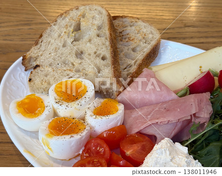 Close up breakfast plate with cheese ham radish greens and soft boiled eggs. Food detail, fresh ingredients, healthy lifestyle, cafe serving, appetizing composition 138011946