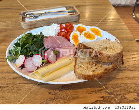 Breakfast plate with eggs cheese ham vegetables and bread on wooden table. Healthy meal, balanced nutrition, cafe style serving, morning routine, fresh ingredients 138011952