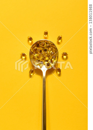 Golden spoon with soft gels vitamin D (cholecalciferol) in shape of sun Golden spoon with soft gels vitamin D (cholecalciferol) in shape of sun 138011988