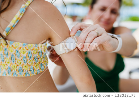 Mother taking care of diabetic girl with glucose monitor. Mother taking care of diabetic girl with glucose monitor. 138012175