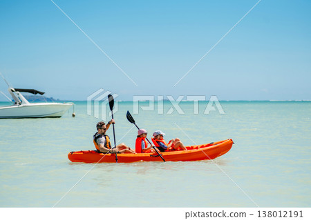 Father kayaking with children on calm sea during family summer vacation. Father kayaking with children on calm sea during family summer vacation. 138012191