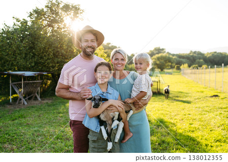 Family petting little goat at farm. 138012355