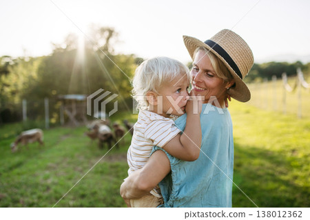 Mom and kid looking at animals at farm. 138012362