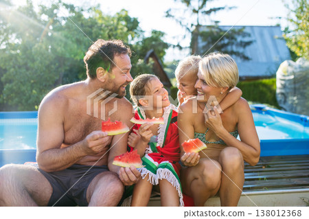 Young family with two children eating watermelon after in swimming in pool. Young family with two children eating watermelon after in swimming in pool. 138012368