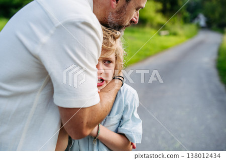 Father comforting upset son during emotional moment outdoors. Father comforting upset son during emotional moment outdoors. 138012434