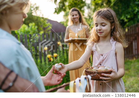 Girl giving decorated Easter eggs to boy after Easter Monday tradition. Girl giving decorated Easter eggs to boy after Easter Monday tradition. 138012446