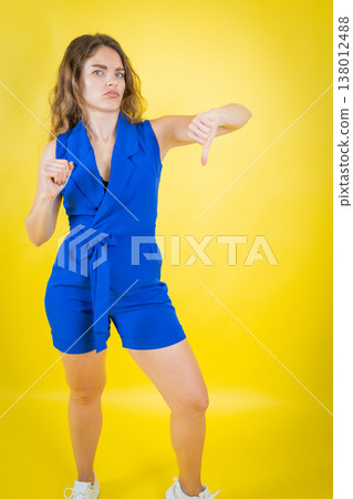 Woman expressing dislike with thumbs down gesture Woman expressing dislike with thumbs down gesture 138012488
