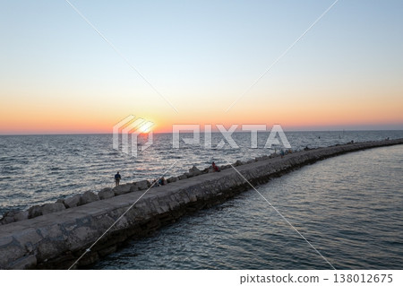 Stone pier leading into Adriatic Sea at sunset in Istria 138012675