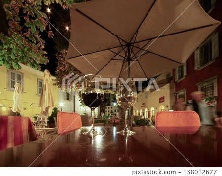 Wine glasses on table in cozy outdoor restaurant at night 138012677