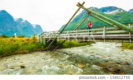 Tourist relaxing on bridge in village Oppstryn Norway Tourist relaxing on bridge in village Oppstryn Norway 138012730