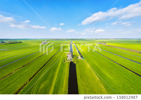 Aerial view of traditional Dutch windmills by water canals in a green field. Aerial view of traditional Dutch windmills by water canals in a green field. 138012987