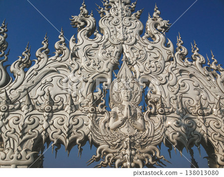 Intricate white carving of a deity at Wat Rong Khun White Temple in Chiang Rai 138013080