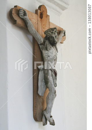Ancient wooden crucifix statue of Jesus Christ on a white wall Ancient wooden crucifix statue of Jesus Christ on a white wall 138013087