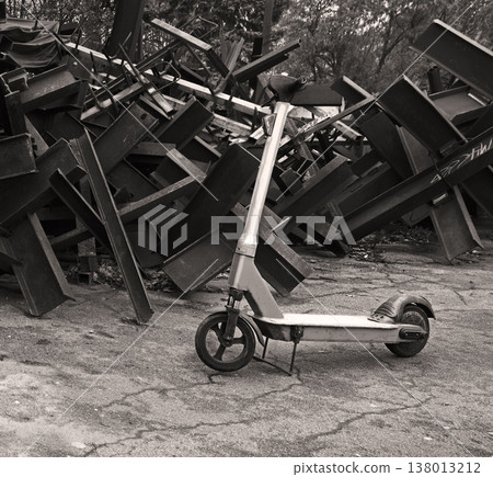 A scooter against the backdrop of iron anti-tank hedgehogs 138013212