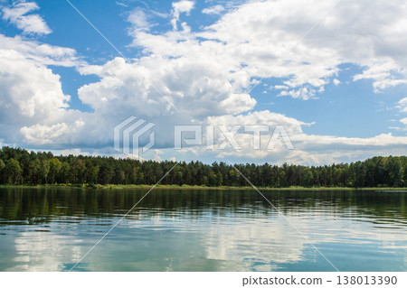beautiful lake landscape with blue sky and clouds and a row of trees on the horizon beautiful lake landscape with blue sky and clouds and a row of trees on the horizon 138013390