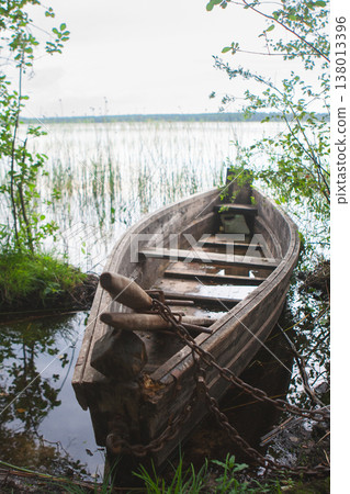 Old wooden rowing boat moored at a lake shore in Ukraine Old wooden rowing boat moored at a lake shore in Ukraine 138013396