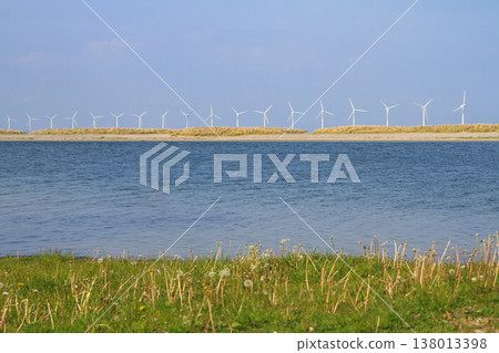 many windmills standing in the sea generate electricity 138013398