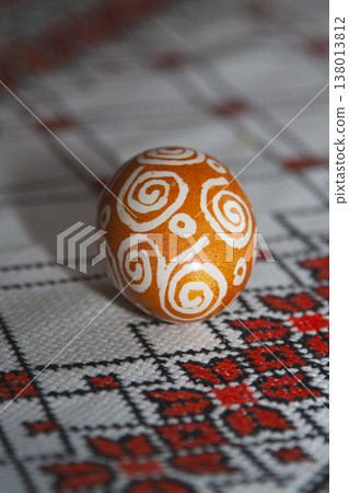 Close-up of a traditional Ukrainian pysanka on an embroidered tablecloth Close-up of a traditional Ukrainian pysanka on an embroidered tablecloth 138013812