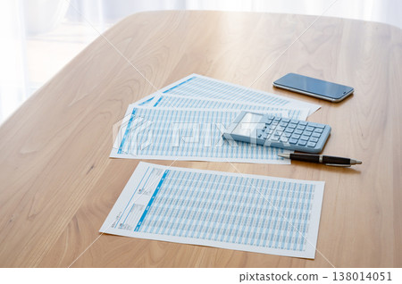 桌上有貸款計算表、計算機和智慧型手機。 138014051