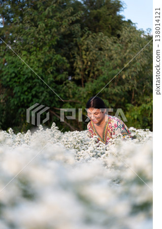 lgbtq person surrounded by white flowers enjoying nature expressing identity pride calm emotion and peaceful outdoor lifestyle in blooming field 138014121