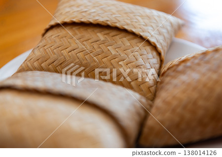 Sticky rice served in woven bamboo baskets with warm tones and soft focus highlighting traditional thai food texture natural materials and cultural authenticity Sticky rice served in woven bamboo baskets with warm tones and soft focus highlighting traditional thai food texture natural materials and cultural authenticity 138014126