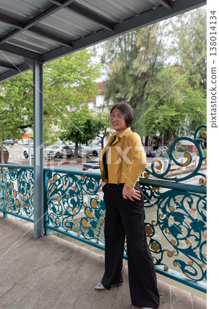 Confident lgbtq person standing on decorative urban bridge smiling showing self expression identity pride lifestyle diversity and modern city life concept Confident lgbtq person standing on decorative urban bridge smiling showing self expression identity pride lifestyle diversity and modern city life concept 138014134