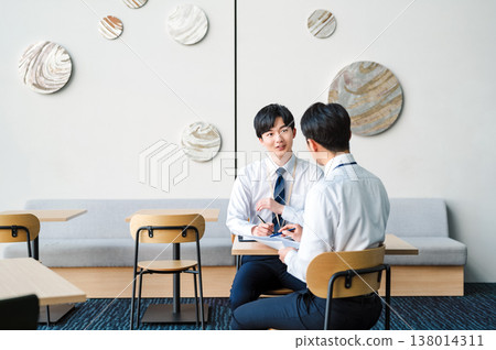 年輕的商人在辦公大樓的空地上開會。 138014311