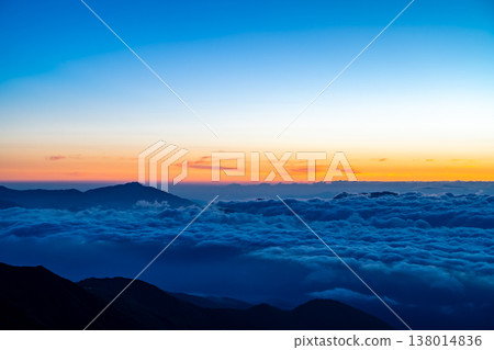 Magic hour view of Mt. Myoko and the sunrise from Mt. Shirouma. Traverse hike from Mt. Shirouma to Mt. Yukikura in the Northern Alps. Magic hour view of Mt. Myoko and the sunrise from Mt. Shirouma. Traverse hike from Mt. Shirouma to Mt. Yukikura in the Northern Alps. 138014836