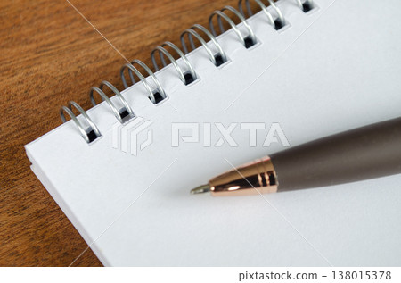 Blank spiral notebook on a wooden desk with a sharpened pencil and ample copy space, with customizable space on notebook for text or ideas. Blank spiral notebook on a wooden desk with a sharpened pencil and ample copy space, with customizable space on notebook for text or ideas. 138015378