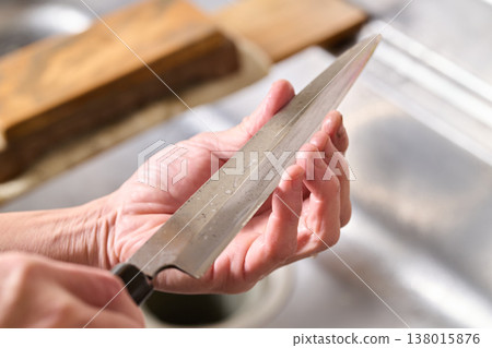 A man tests the sharpness of a kitchen knife. A man tests the sharpness of a kitchen knife. 138015876