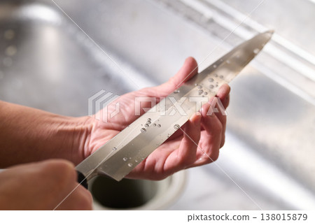 一名男子正在測試一把廚房刀的鋒利度。 138015879