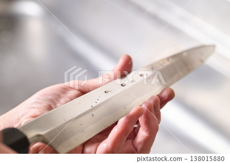 A man tests the sharpness of a kitchen knife. A man tests the sharpness of a kitchen knife. 138015880
