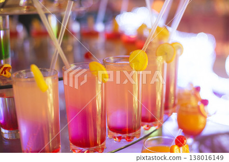 Sunset-colored gradient cocktails on a tiered display at a celebration Sunset-colored gradient cocktails on a tiered display at a celebration 138016149