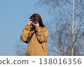 A woman holding a camera 138016356