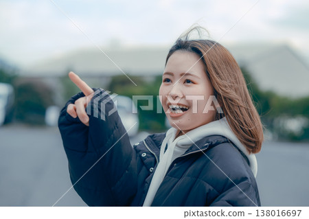 A smiling woman in her 20s walking through the streets of a tourist town. A smiling woman in her 20s walking through the streets of a tourist town. 138016697