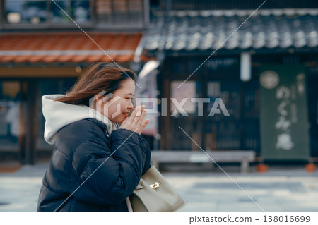 A smiling woman in her 20s walking through the streets of a tourist town. A smiling woman in her 20s walking through the streets of a tourist town. 138016699