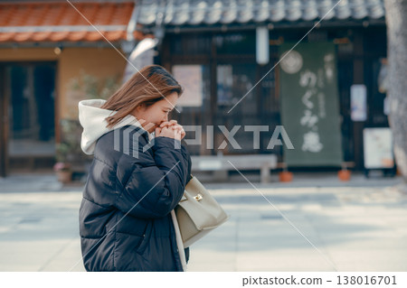 A smiling woman in her 20s walking through the streets of a tourist town. 138016701