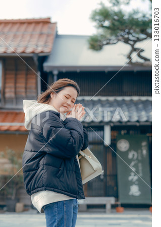 A smiling woman in her 20s walking through the streets of a tourist town. A smiling woman in her 20s walking through the streets of a tourist town. 138016703