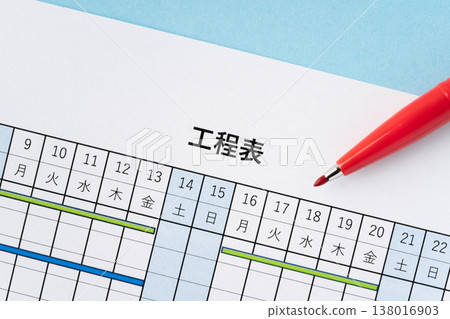 A light blue background with a project schedule and red pen. A light blue background with a project schedule and red pen. 138016903