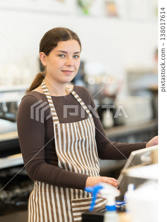Woman standing at the counter in a coffee shop 138017614