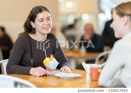 Young woman chatting with teenager in cafe Young woman chatting with teenager in cafe 138017643